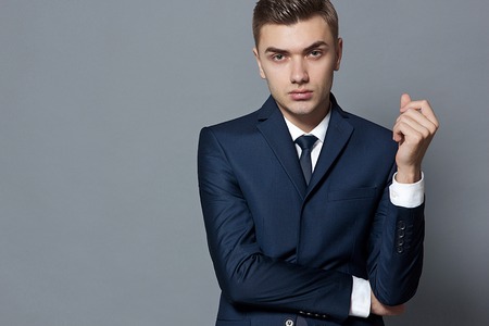 man in dark blue suit white shirt and tie posing studioの写真素材