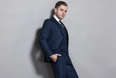 man in blue suit with vest in studio on gray backgroundの写真素材
