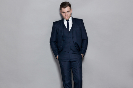 man in blue suit with vest in studio on gray backgroundの写真素材