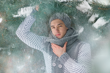 Guy in a jacket and hat in winter, snowの写真素材