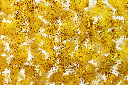 golden smears on a white background sprinkled with gold sparklesの写真素材