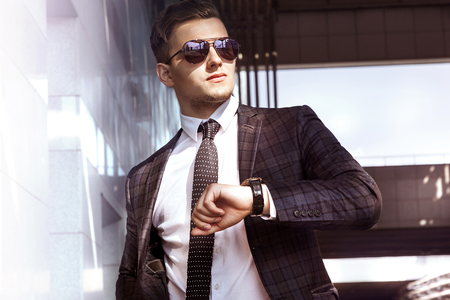 man businessman in sunglasses jacket and tie against the background of urban landscapeの写真素材