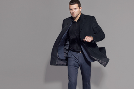 man in a black coat on a gray background studioの写真素材