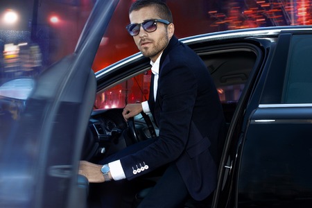 Handsome brutal man in luxury car. Night life.の写真素材
