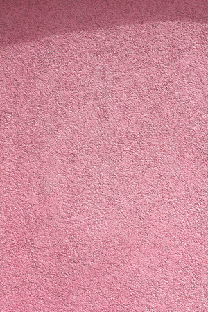 pink wall with a shadow from a canopy cement wall texture backgroun. Colors of decorative plasters. For architects and designersの写真素材