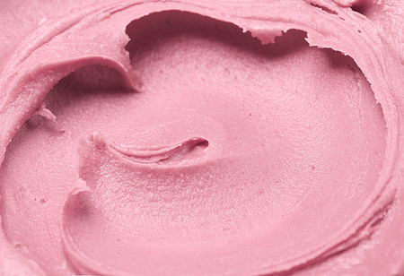 Soft pink cosmetic clay facial mask, cream texture close up, selective focus. Abstract background with brushの写真素材