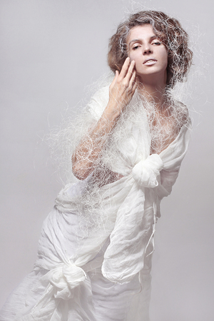 art photo of a girl in a haute couture costume of a fancy white cotton dress on a white background in isolationの写真素材