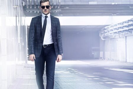 A man walks in a suit on the background of the modern cityの写真素材