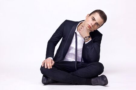 guy in a suit sitting in a lotus position on a white background, studioの写真素材