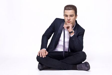 guy in a suit sitting in a lotus position on a white background, studioの写真素材