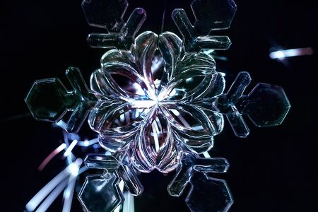 large plastic snowflake in neon light illuminated by sparklersの写真素材