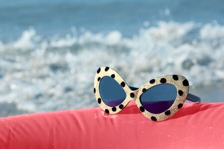 sunglasses on the background of the sea surfの写真素材