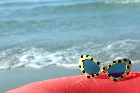 sunglasses on the background of the sea surfの写真素材