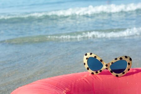 sunglasses on the background of the sea surfの写真素材