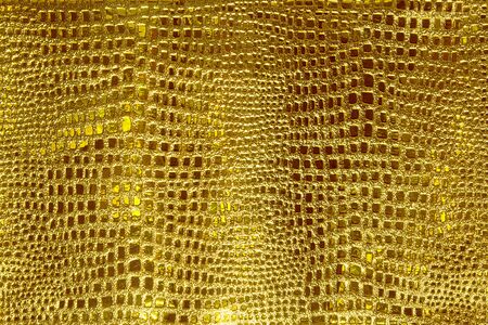 background of the golden skin of a snake, alligator, python, fashion, luxuryの写真素材