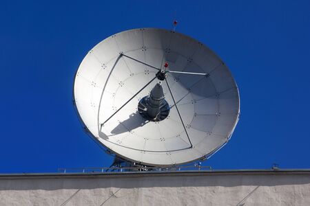 Dish antenna for satellite communications on the roof of an office buildingの写真素材