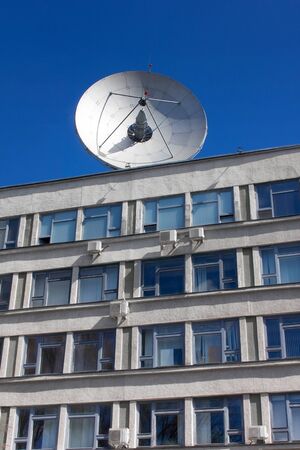 Dish antenna for satellite communications on the roof of an office buildingの写真素材