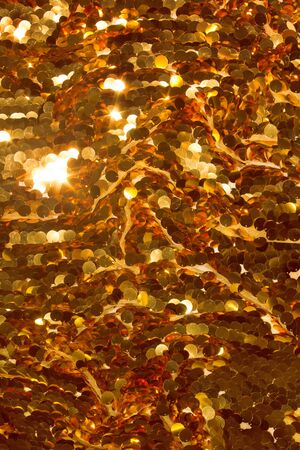 Holiday background from gold glitter paillettes, close up.の写真素材