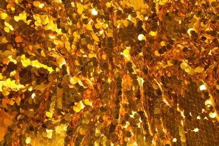 Holiday background from gold glitter paillettes, close up.の写真素材