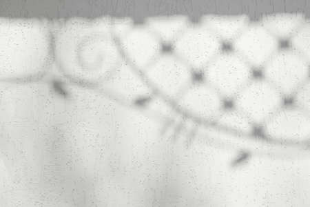 white wall with a shadow from the forged lattice