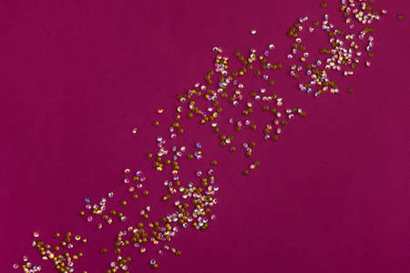 Multi-colored rainbow rhinestones scattered on a cherry background.の写真素材