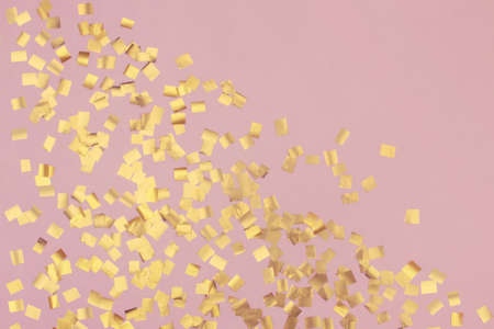 Pink festive background with golden sparkles in the shape of squares.