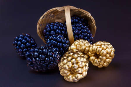blackberries in a small wicker basket on a dark backgroundの写真素材
