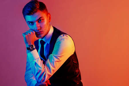 Fashion portrait of handsome man posing in colorful bright neon uv blue and red lights.の写真素材