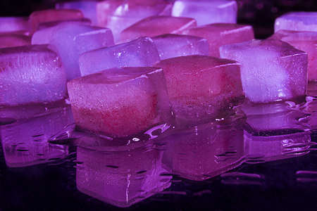 Pink violet Lilac ice cubes lies on a black background.の写真素材