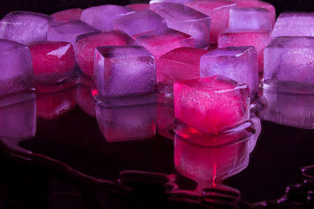 Pink violet Lilac ice cubes lies on a black background.の写真素材