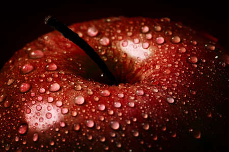 Close-up of Water droplet on glossy surface of freshness red apple on black backgroundの写真素材