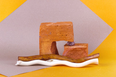 Red brick podium for advertising cosmetic products. Yellow-pink background. Wabi sabi concept.の写真素材