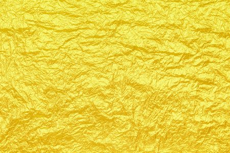 Beautiful crumpled foil of bright yellow color as a background texture on holiday banners.の写真素材