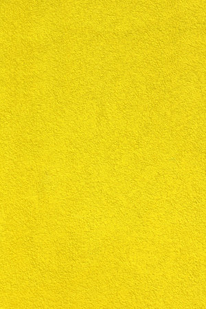 The bright yellow vertical wall is covered with plaster texture. Your background for a festive banner.の写真素材