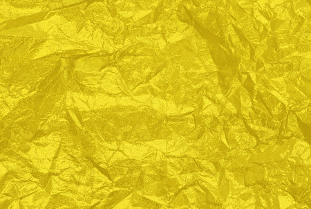 Beautiful crumpled foil of bright yellow color as a background texture on holiday banners.の写真素材