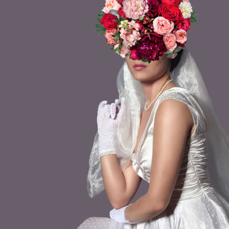 Bride with floral hairstyle. Woman with a bouquet on her head. Vogue style portrait.の写真素材