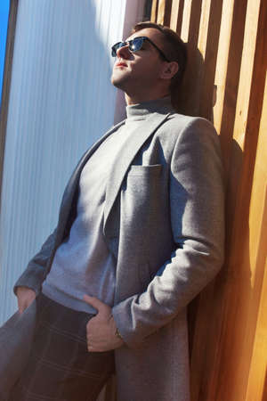 A man in a gray coat in the city. Demi-season fashion.の写真素材