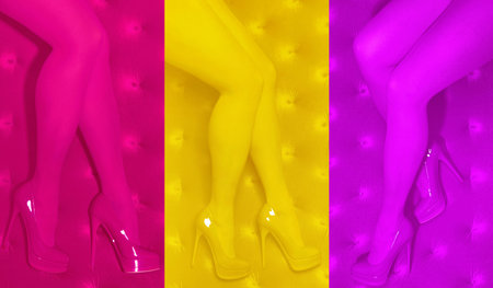 female legs in pink, yellow, purple tights on a bright multicolored background, monochromeの写真素材