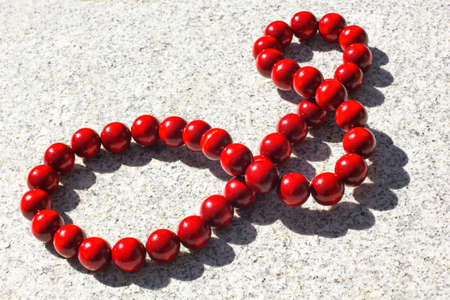 Large red wooden beads illuminated by the sun with shadowの写真素材