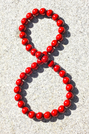Large red wooden beads illuminated by the sun with shadowの写真素材