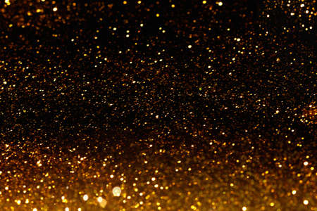 Background texture, small gold sparkles on a black background.の写真素材