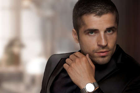 Portrait of a man in a wristwatch against the backdrop of a rich interiorの写真素材