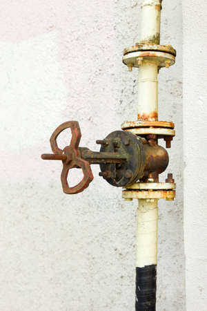 rusty pipe valve on white wall backgroundの写真素材