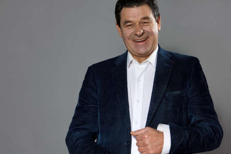 mature man in a suit is indignant and shouting, gray background, studioの写真素材