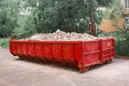 Red container with solid domestic and construction waste.の写真素材