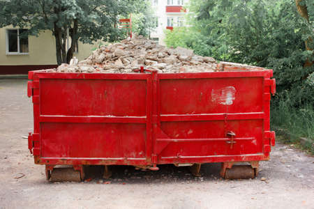 Red container with solid domestic and construction waste.の写真素材