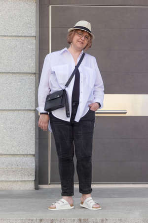 Portrait of mature plus size woman in business style walking around the city and smiling. Life of women after 40-50 yearsの写真素材