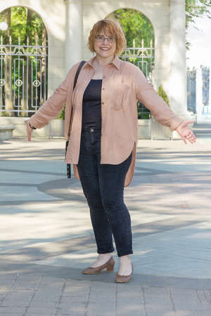 Full length portrait of plus size mature woman in casual style walking around the city on a nice sunny day. Life of a woman after 50 yearsの写真素材
