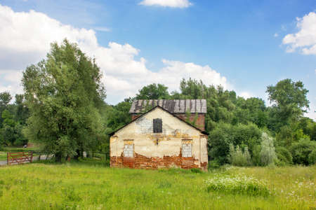 Old brickwork of an old house with broken and brick windows made of various types of bricks and building materials.の写真素材