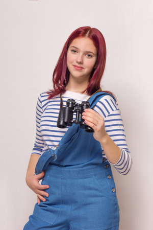 girl in a blue denim overalls and a striped blouse on a white isolated background. Summer, sea theme.の写真素材